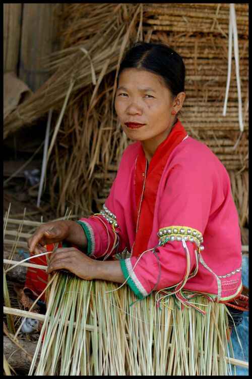 femme thai en train de tresser des paillasses