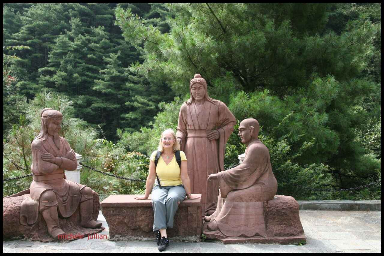 michele jullian devant des statues en chine
