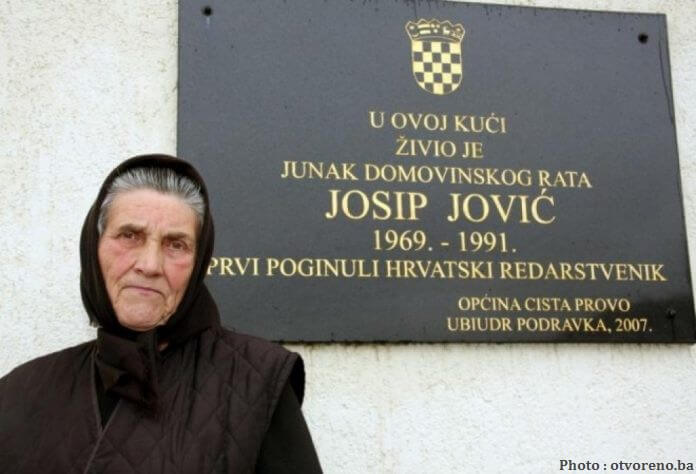 Marija Jovic devant la plaque commémorative en l'honneur de son fils Josip Jovic, 1ère victime de la guerre de Croatie