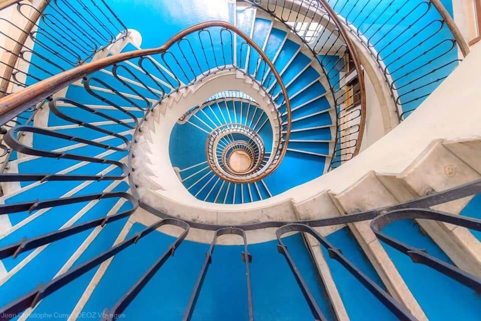 escalier aux marches bleues en colimaçon dans un immeuble Bauhaus Budapest
