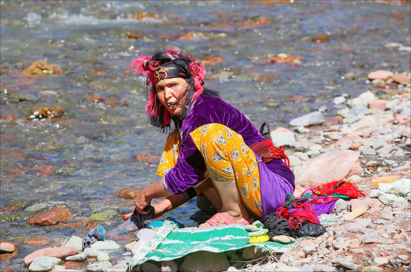 femme berbère lavant son linge dans une rivière au maroc