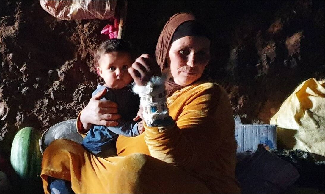 femme berbère portant un bébé et vivant dans une grotte au maroc