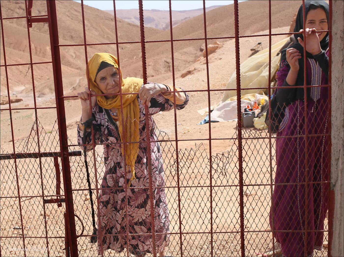femmes berbères derrières des grilles dans un bivouac au maroc