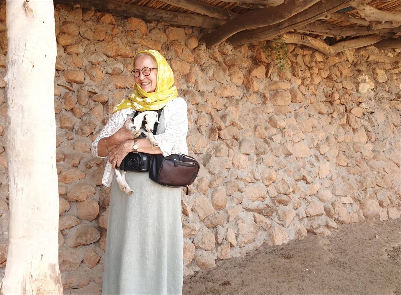 michele jullian portant un agneau dans un village berbère au maroc