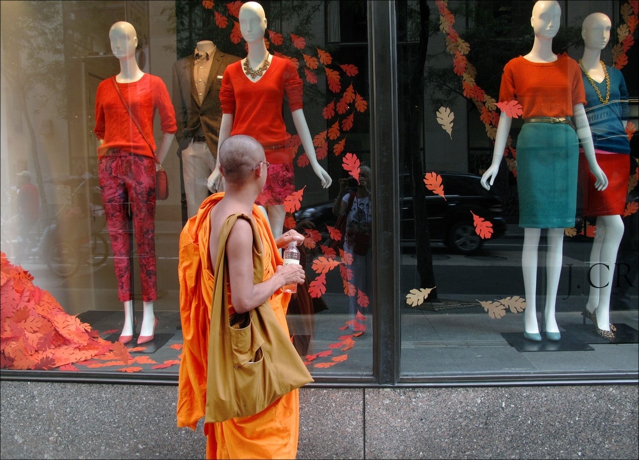 moine bouddhiste devant une vitrine de mode à new york