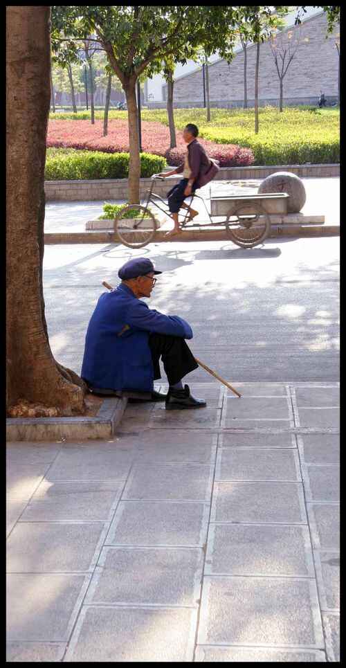 vieil homme assis avec une canne et homme sur son vélo en chine Yunnan, 3
