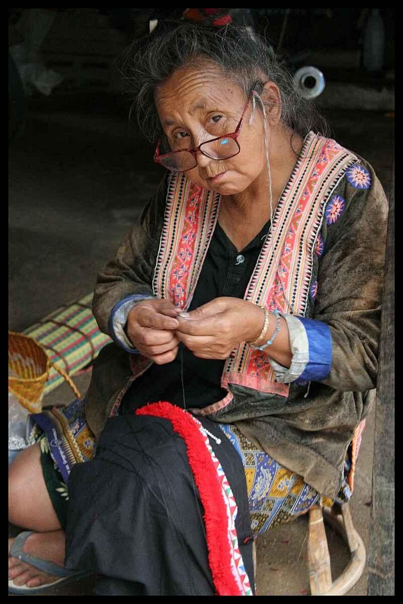 vieille femme hmong en train de coudre