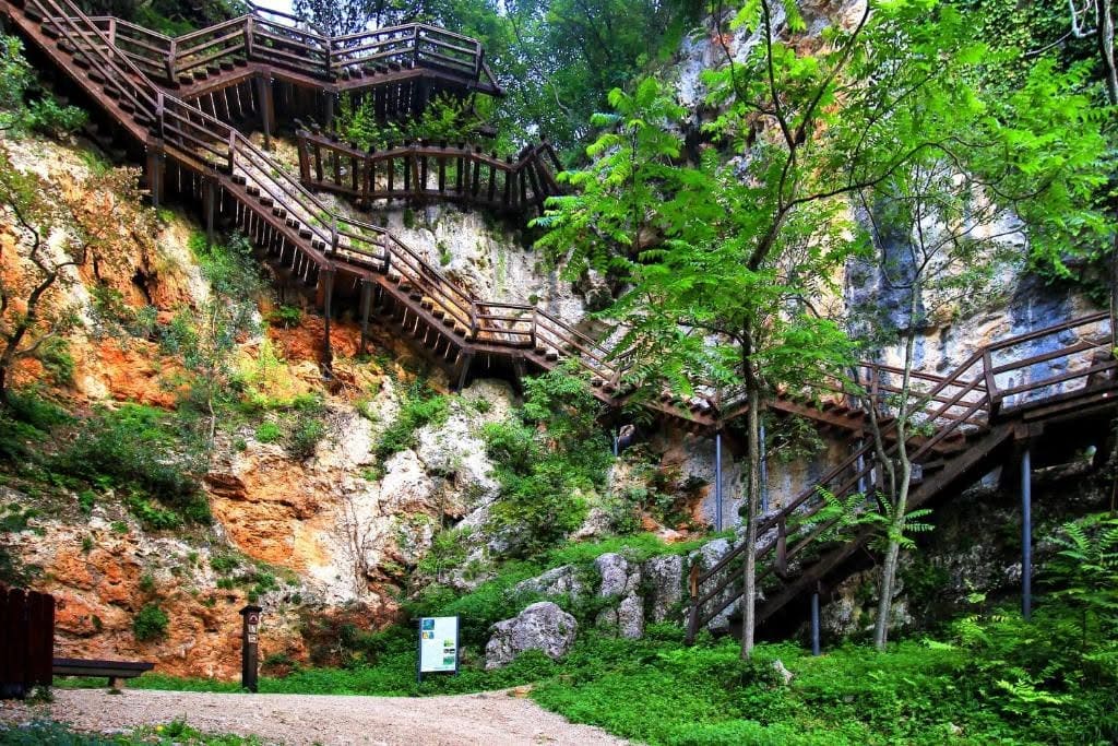 Escaliers en bois et paliers montant à flanc de falaise vers la grotte Oziđana