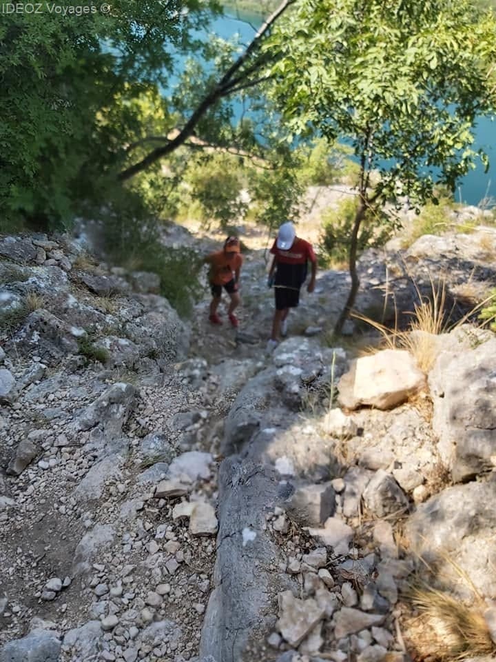 Deux randonneurs montent un sentier pentu et caillouteux à Krka