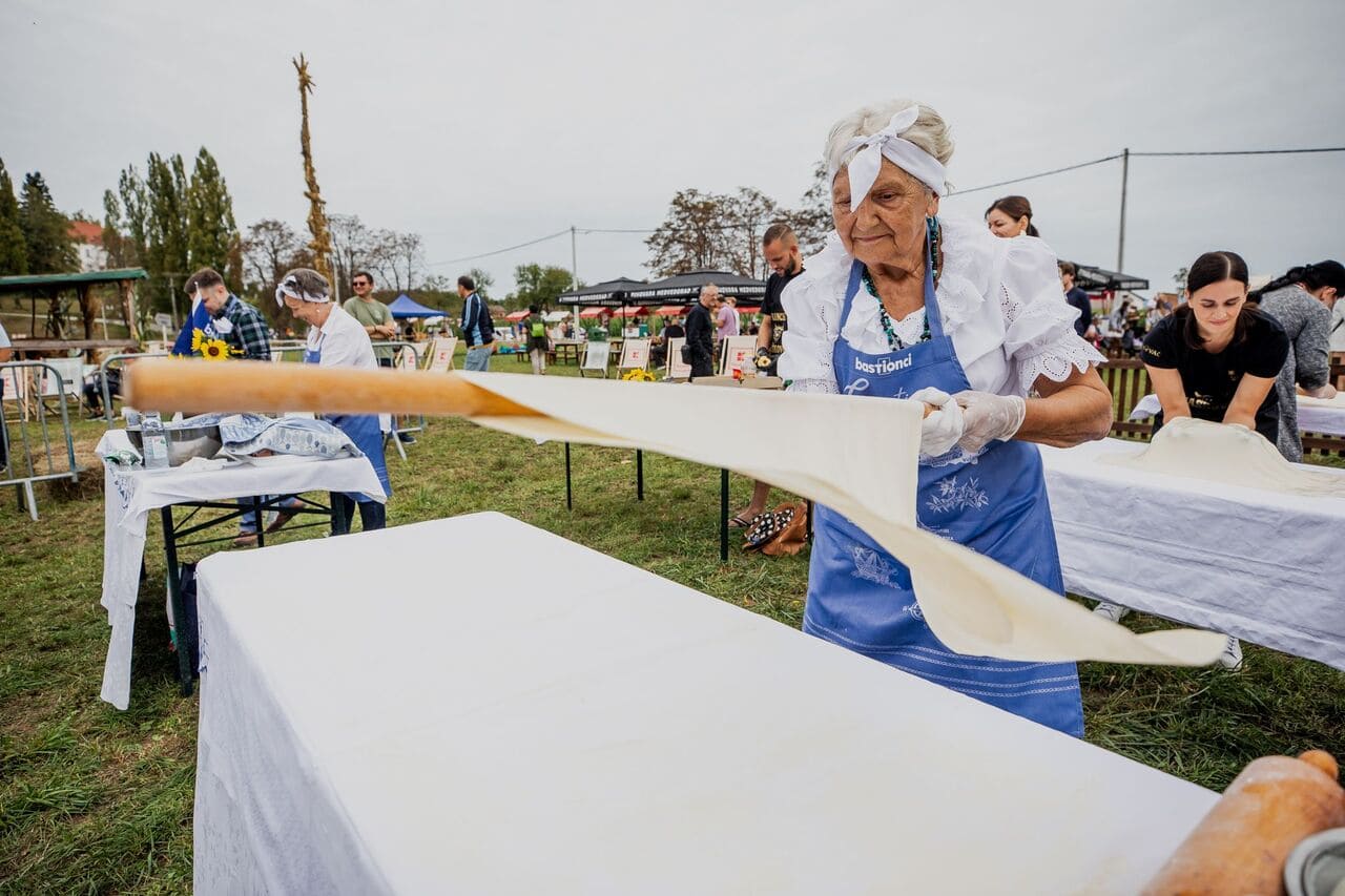 Préparation traditionnelle de la štrudla avec une pâte étirée très finement à Jaškovo