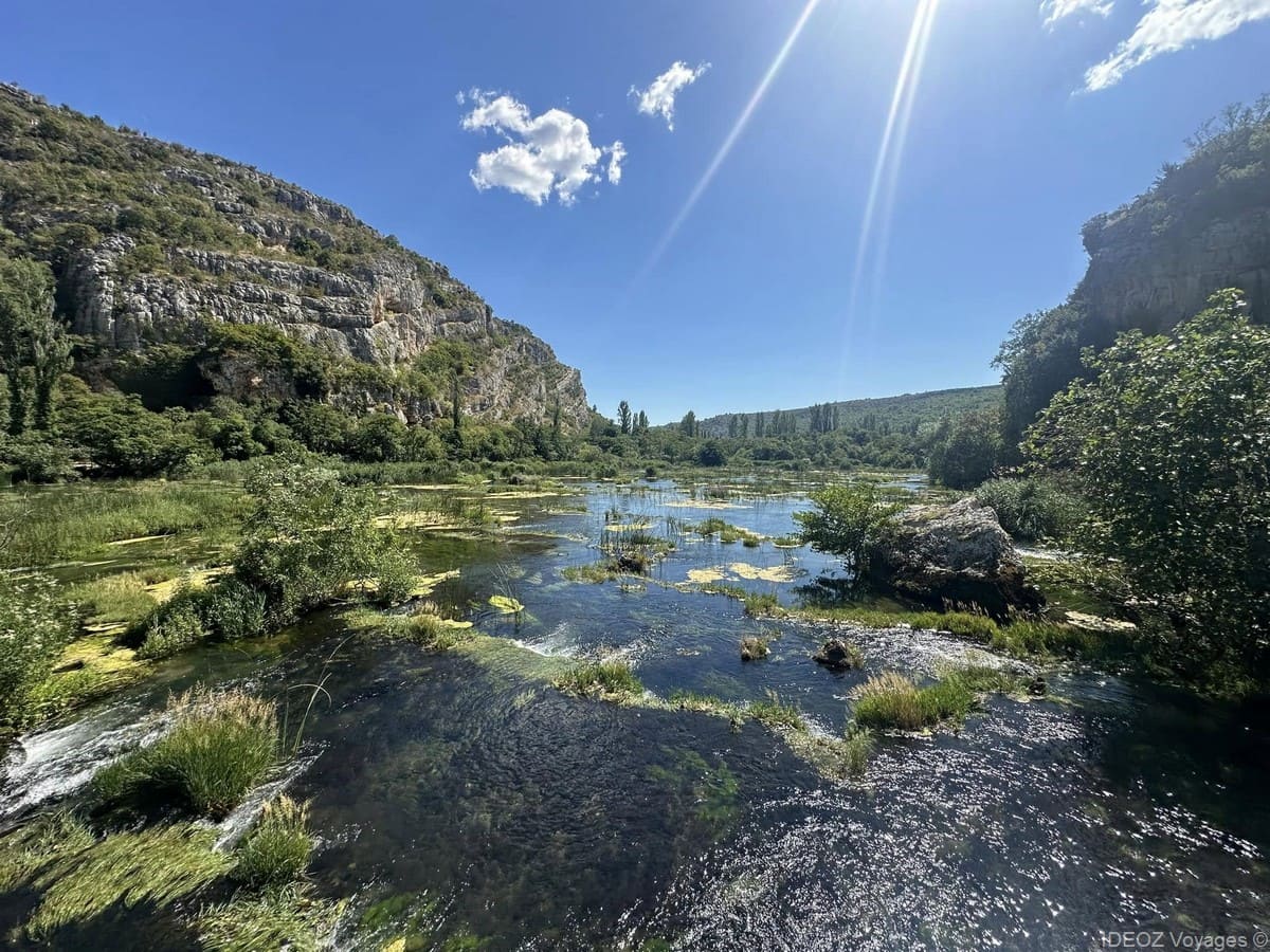 La rivière Krka se divise autour d’îlots de végétation entre les parois rocheuses du canyon