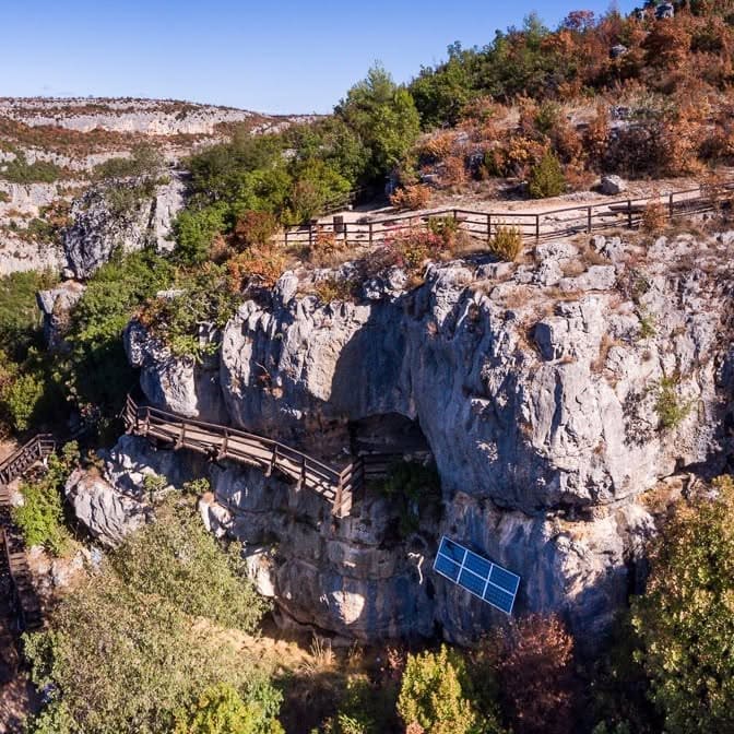 Sentier aménagé menant à Oziđana pećina dans le paysage karstique de Krka avec une végétation rousse et verte à la fin de l’automne