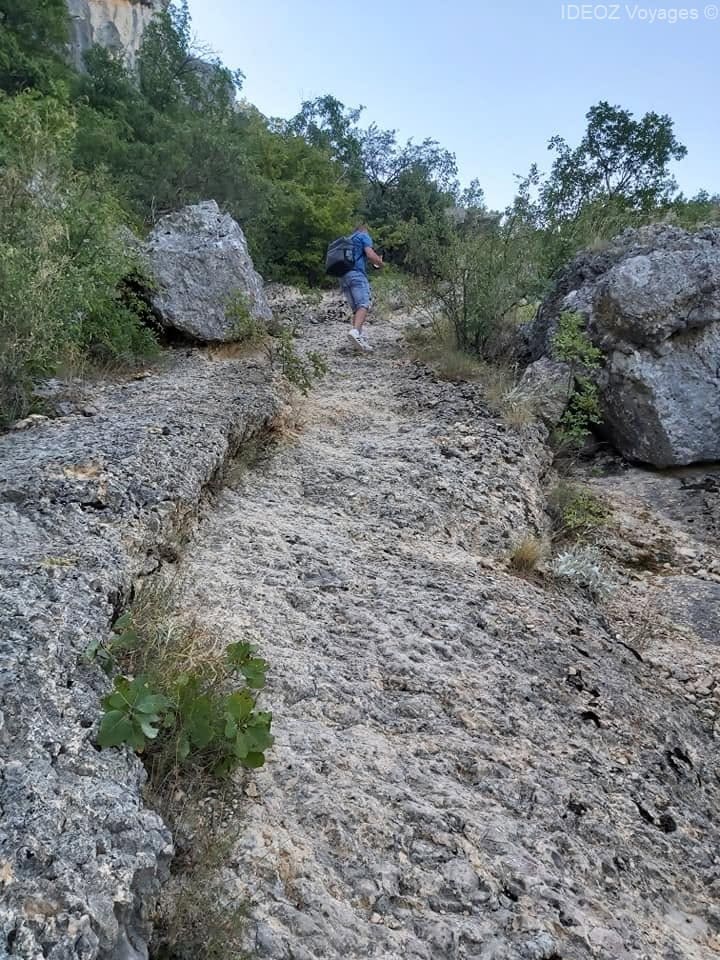 Randonneur montant sur un passage rocheux et irrégulier du sentier de Krka