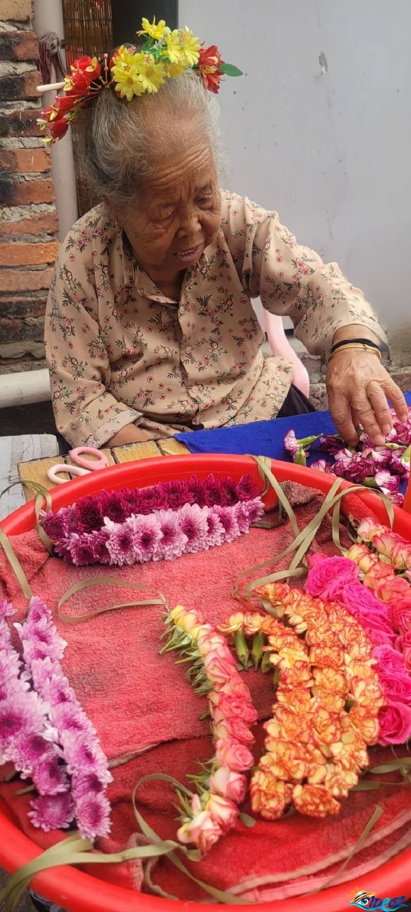 femme de xunpu préparant des couronnes de fleurs