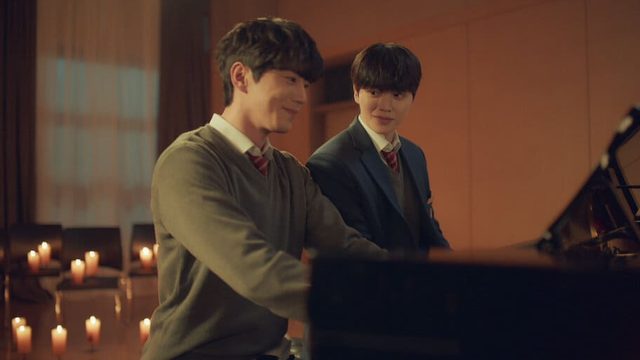 Deux jeunes pianistes échangent un regard complice autour d'un piano, dans une pièce éclairée à la bougie, dans le drama coréen Quatre Mains, deux sonates.