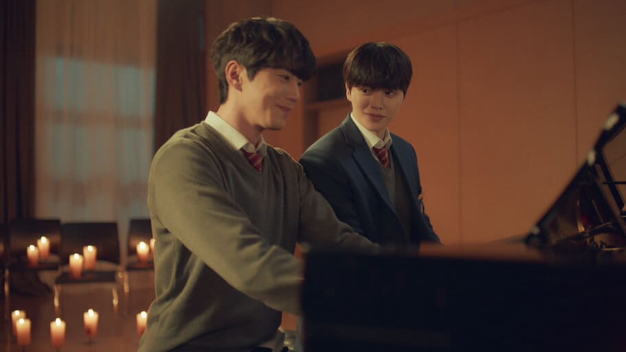 Deux jeunes pianistes échangent un regard complice autour d'un piano, dans une pièce éclairée à la bougie, dans le drama coréen Quatre Mains, deux sonates.