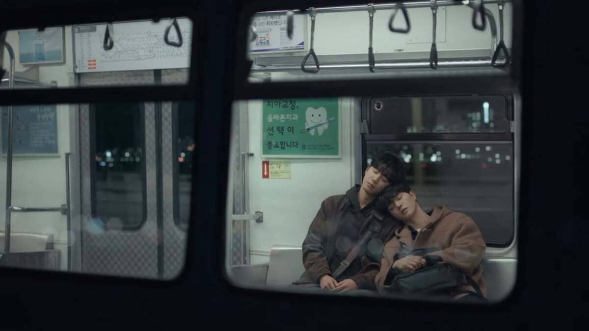 Deux jeunes hommes endormis, la tête appuyée l'un contre l'autre dans une rame de métro, dans le drama coréen Quatre Mains, deux sonates.