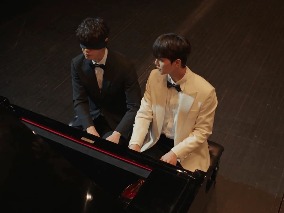 quatre mains deux sonates pio et choi avec les yeux bandés devant le piano
